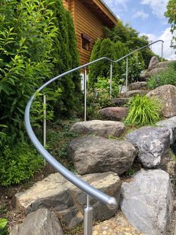 Geschwungener Handlauf an einer Natursteintreppe entlang - Bernet «Flexo Handläufe»